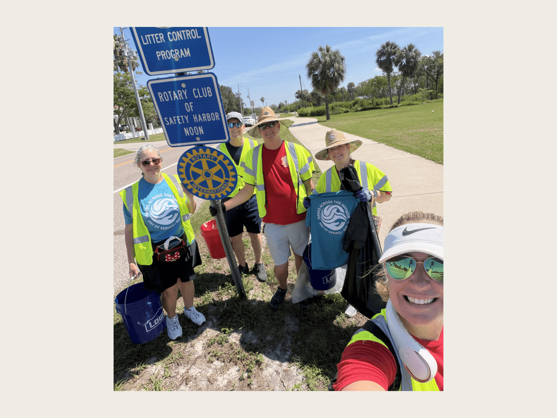 Group of volunteers picking up trash on road, for Hands Across the Harbor, a local event